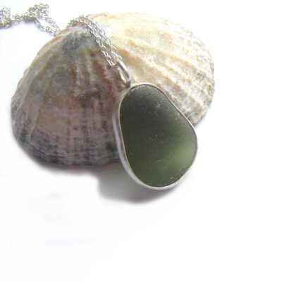 Bottle Green Sea Glass Bezel Pendant. This English sea glass pendant is handmade with genuine sea glass, shaped and frosted naturally by the North Sea’s tides, and washed up on its shores. I have collected the sea glass by hand on the lovely north-east coast. The sea glass is set in a handcrafted silver bezel surround. From Northumbria Gems.