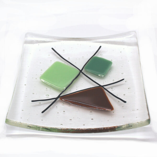 Geometric glass dish tan and mint greens on clear. This retro dish is made in a sixties-inspired design featuring geometric shapes intersected with black lines. Handcrafted using fused glass techniques. Made in England.