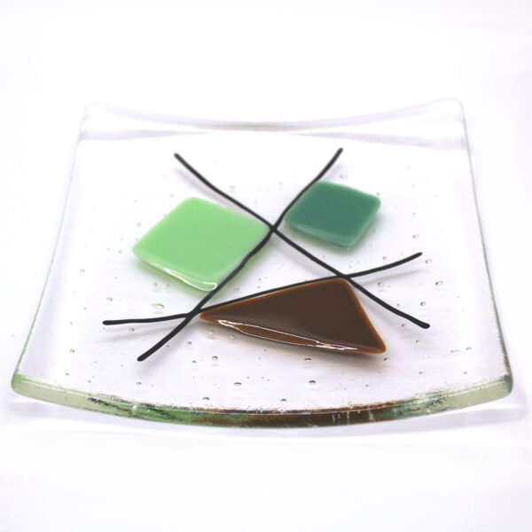 Geometric glass dish tan and mint greens on clear. This retro dish is made in a sixties-inspired design featuring geometric shapes intersected with black lines. Handcrafted using fused glass techniques. Made in England.