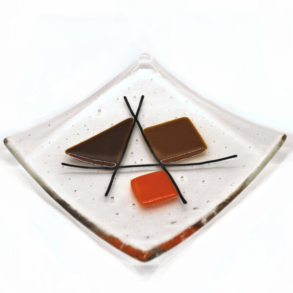 Geometric glass dish tan and orange on clear. A sixties retro dish with tan, brown and orange shapes intersected with black lines. Handcrafted using fused glass techniques. Made in England.