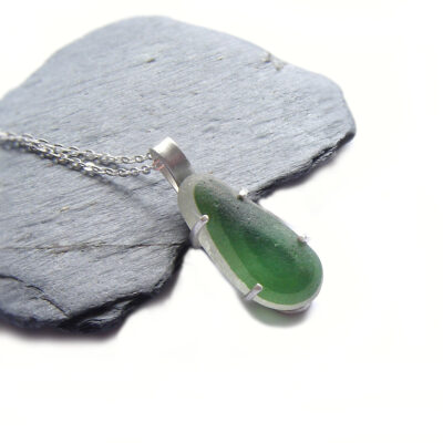 Rare Green English Multi Seaglass Pendant handmade with rare, multicoloured 'end of day' seaglass which has three bands of green at the front, the darkest green at the centre. I have collected this seaglass by hand at Seaham, on the coast of County Durham. The sea glass is set in a handcrafted brushed silver claw or prong setting which has been fully hallmarked in England. English Seaglass Necklace from Northumbria Gems.