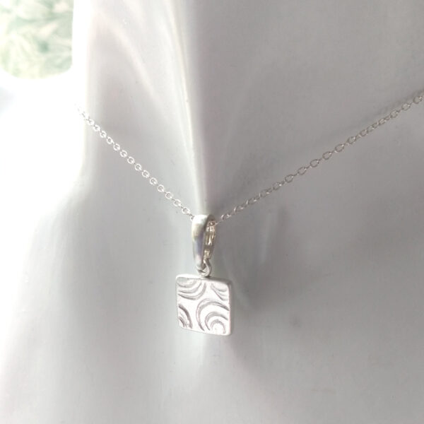 Tiny Water Ripples Pendant. A handmade contemporary silver necklace in a geometric, broken circles design. Ethical silver necklace handcrafted in England.