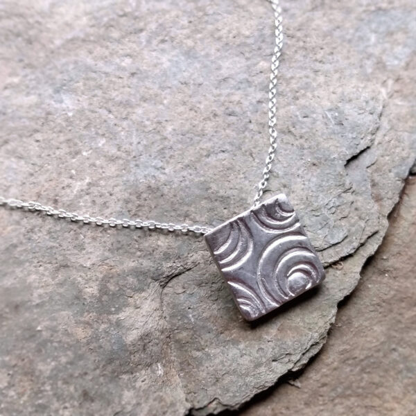 Water Ripples Pendant. Contemporary silver pendant necklace in a broken concentric circles geometric design. Handcrafted in England.