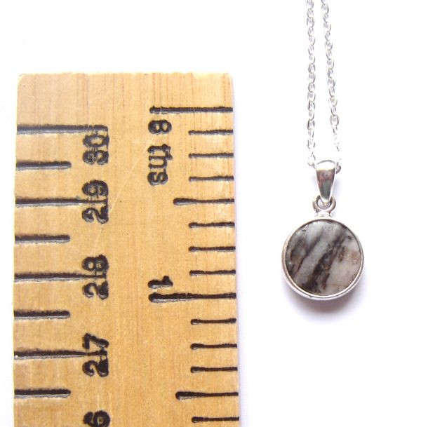 Banded British Stone Pendant. A men's or women's pendant in white and black striped stone, handcrafted into a cabochon and set in a round, sterling silver pendant. The gemstone in this pendant is British gneiss, collected in Northumbria, England, and most likely originating in Lewis off the west coast of Scotland. Natural British gemstone pendant by Northumbria Gems.