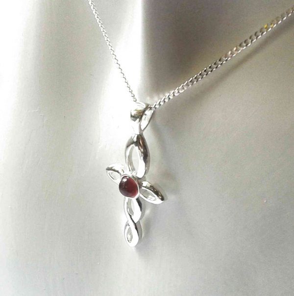 Small Celtic cross pendant set with a handcrafted tiny red garnet gemstone cabochon. Twist design cross necklace.