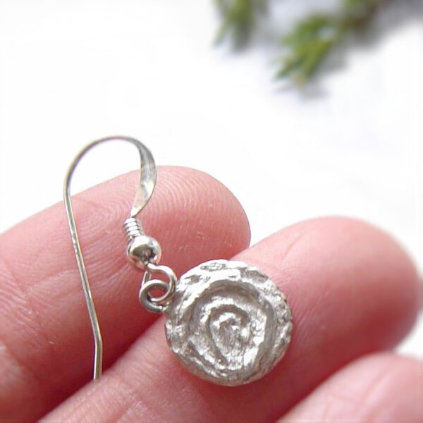 Cup and Ring Marks Silver Earrings. Small, round drop earrings with a textured finish inspired by Northumberland's prehistoric rock art, the broken concentric circles in the style of cup and ring marks.Individually handcrafted in the north-east of England, and hallmarked. By Northumbria Gems.