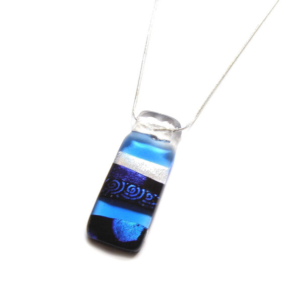Blues and Swirls Layered Dichroic Pendant. A large, abstract statement pendant handmade in alternating plain and patterned dichroic fused glass, the colours varying in different lights. Made in England.