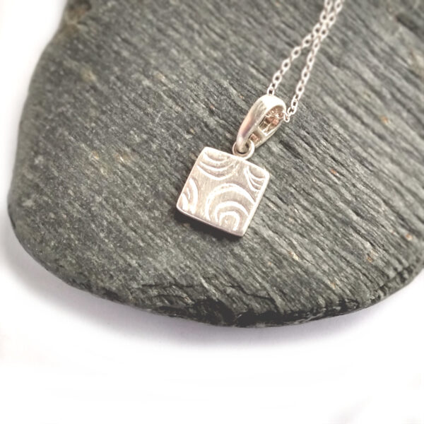 Tiny Water Ripples Pendant. A handmade contemporary silver necklace in a geometric, broken circles design. Ethical silver necklace handcrafted in England.